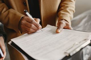 Devis de travaux signé posé sur une table, à côté d'un carnet de chantier